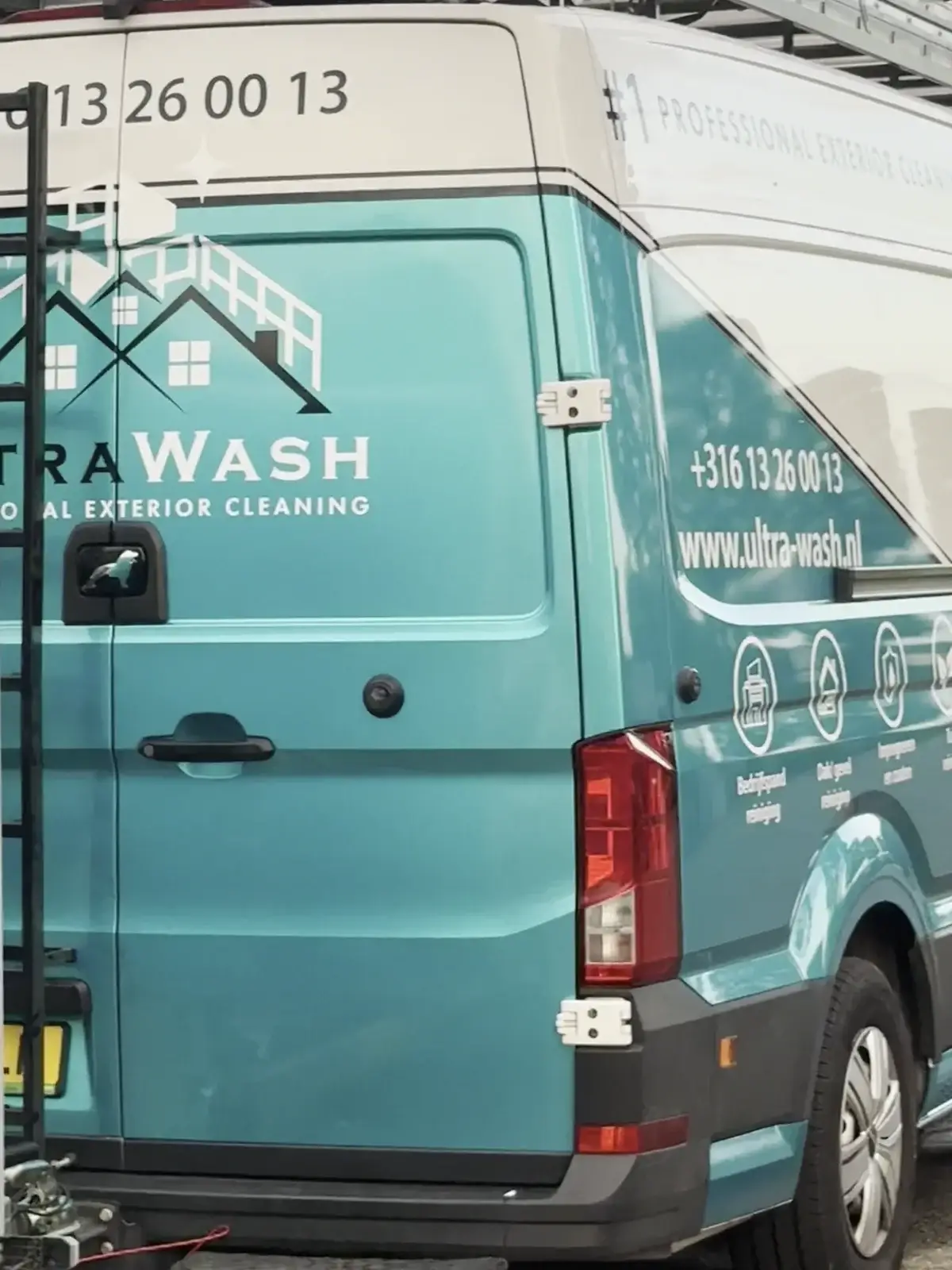 Achterzijde van een van onze turquoise Ultra Wash-bussen met diensten op de deuren