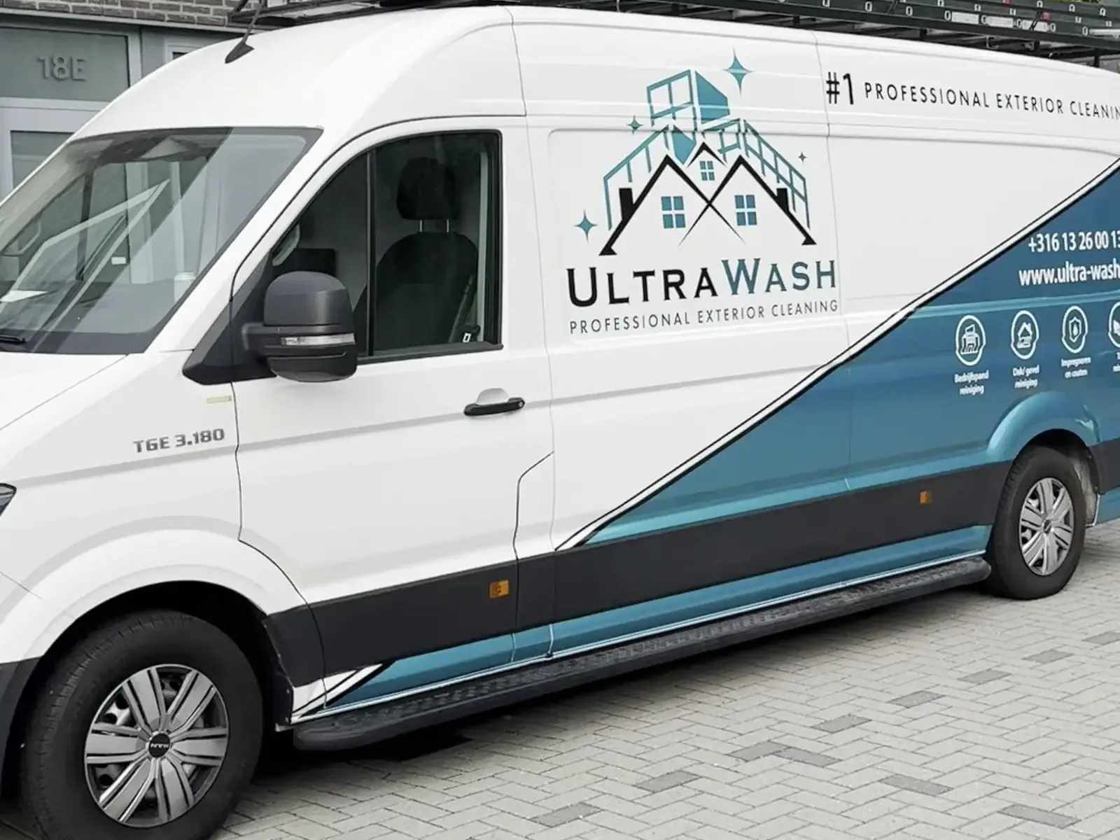 Een van onze turquoise Ultra Wash-bussen van opzij met logo en contactgegevens