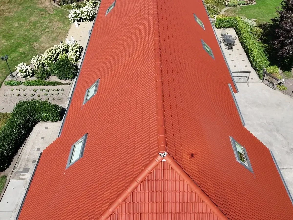 Fel oranje pannendak na dakreiniging, dronebeeld van boven